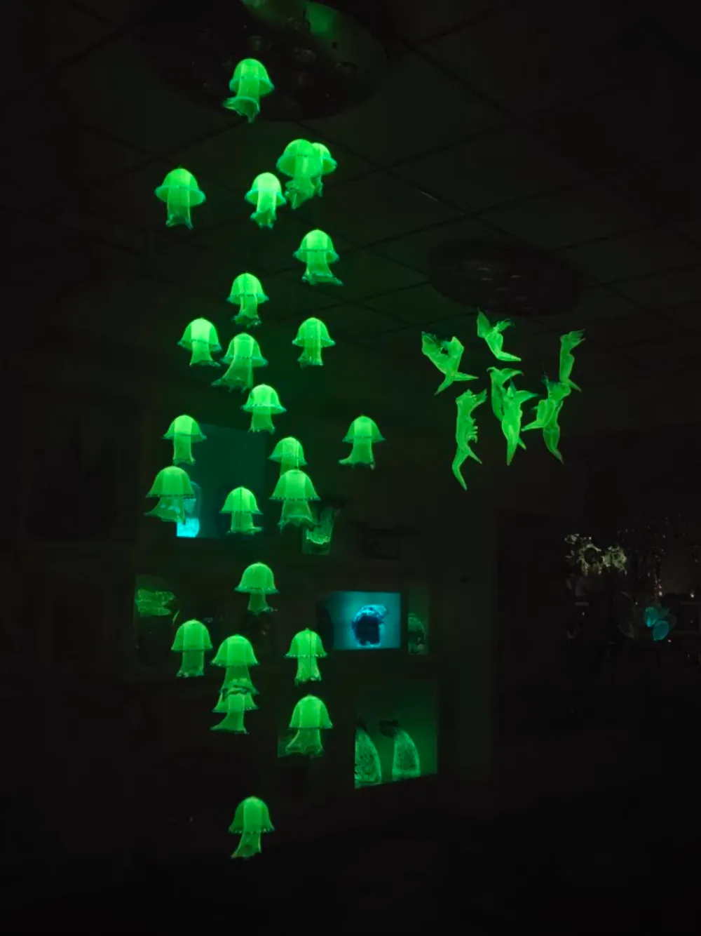 A hanging school of glowing glass jellyfish in the furnace showroom